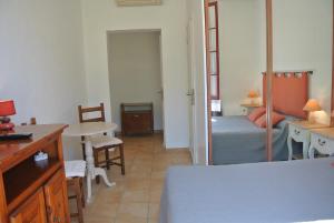 a bedroom with a bed and a desk and a table at Hôtel Castel Mistral in Juan-les-Pins