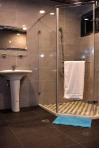 een badkamer met een douche, een wastafel en een toilet bij Yun Dan in Lugu
