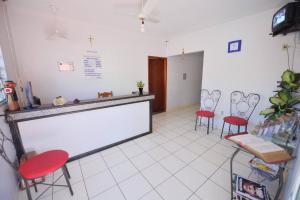 a waiting room with red chairs and a counter at Manhattan Hotel in Caldas Novas