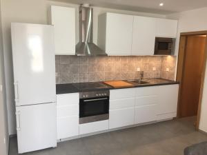 a kitchen with white cabinets and a stove top oven at Central House Nona in Crikvenica