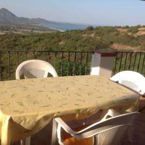 un tavolo e sedie su un balcone con vista di Casa Solaria Villetta singola panoramicissima a Costa Rei