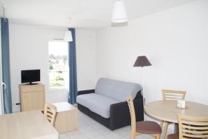 ein Wohnzimmer mit einem Sofa und einem Tisch in der Unterkunft La Résidence Des Oliviers in Bagnols-sur-Cèze