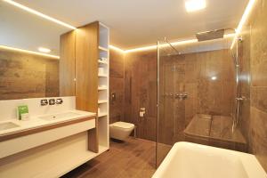 a bathroom with a shower and a sink and a toilet at Hotel Zuiderduin in Egmond aan Zee