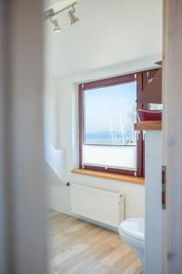 a bathroom with a toilet and a window at Gold Fehmarn in Fehmarn