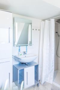 a white bathroom with a sink and a mirror at Gold Fehmarn in Fehmarn