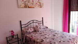 エル・ボスケにあるCasa El Pinsaparのベッドルーム1室(ピンクの掛け布団付きのベッド1台付)