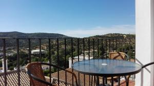 a table and chairs on a balcony with a view at Casa El Pinsapar in El Bosque