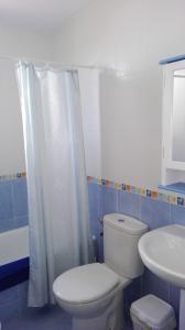 エル・ボスケにあるCasa El Pinsaparのバスルーム(白いトイレ、シンク付)