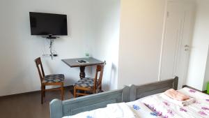 1 dormitorio con 1 cama, 1 mesa y 2 sillas en Privatzimmer Jarosch en Tulln