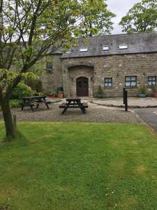 a picnic table in front of a stone building at Middle Flass Lodge in Bolton by Bowland