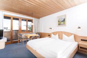 a hotel room with a bed and a table at Fideliushaus in Oberstdorf