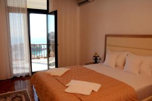 a bedroom with a large bed with an open window at Guest House Smajlaga in Ulcinj