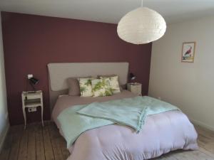 a bedroom with a bed with a purple wall at La Quincaillerie in Audierne