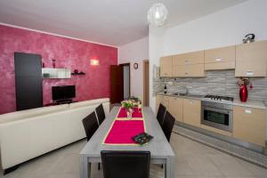 a kitchen with a table with a red table cloth at Appartamento Luminoso in Castellammare del Golfo
