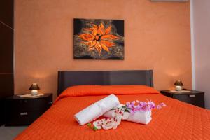 a bedroom with a bed with towels and flowers on it at Appartamento Luminoso in Castellammare del Golfo