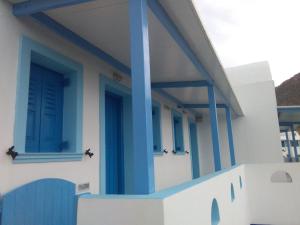 een blauw-wit gebouw met blauwe deuren en ramen bij Panselinos in Anafi
