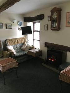 a living room with a couch and a fireplace at Middle Flass Lodge in Bolton by Bowland