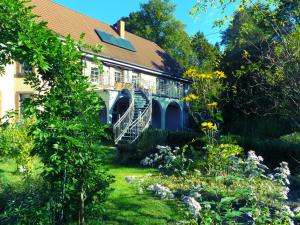 ein Haus mit Garten davor in der Unterkunft Ferienwohnungen Reichholdsmühle in Kaiserslautern