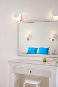 a mirror on a wall with a white bedspread at Terra Blue Santorini in Kamari