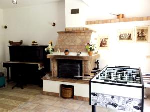 a kitchen with a stone stove and a piano at Villa Adelaide in Belvedere
