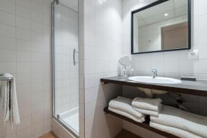 a white bathroom with a sink and a mirror at La Résidence du Bailli in Rayol-Canadel-sur-Mer