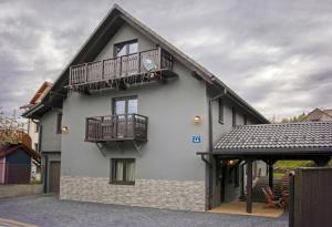 a white building with two balconies on it at Apartamenty Pilsko Korbielów komfortowe mieszkania dla rodzin i narciarzy w Beskidach in Korbielów