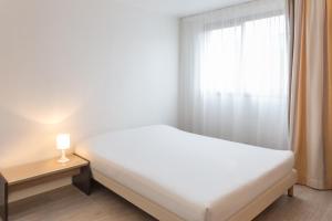 a bedroom with a white bed and a window at City Résidence Aix-en-Provence in Aix-en-Provence