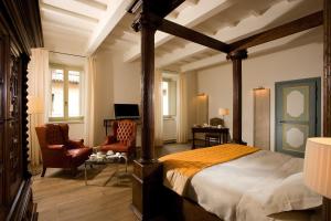 a bedroom with a bed and a living room at Relais & Chateaux Palazzo Seneca in Norcia