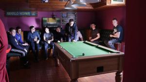 un grupo de personas sentadas alrededor de una mesa de billar en The Seaview Tavern en Ballygorman