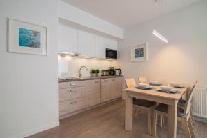 a kitchen and dining room with a table and chairs at Apartament 65 Przy plazy in Władysławowo +4 photos
