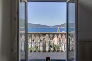 a view of a building from a glass door at St. Roko Guest House in Tivat