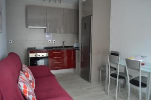 a living room with a red couch in a kitchen at Apartamento Prado - Casa Eva in Ardales