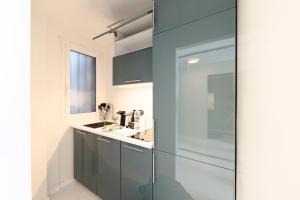 ミラノにあるHeart Milan Apartments Duomo SanBarnabaのバスルーム(ガラス張りのシャワー、シンク付)