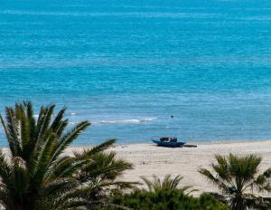 a boat sitting on a beach near the ocean at Aurea Hotel in Tortoreto Lido