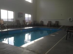 an empty swimming pool with chairs in a building at The Edgewood Hotel and Suites in Fairbury