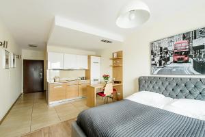 ein kleines Schlafzimmer mit einem Bett und einer Küche in der Unterkunft Angel City Center Krakow Aparthotel in Krakau