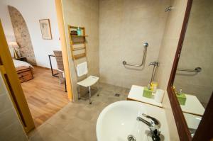 a bathroom with a sink and a mirror and a room at Casa Rural Cruces de Caminos in Plasencia