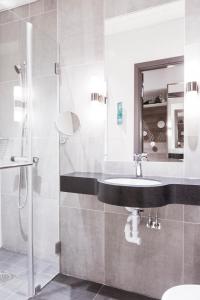 a bathroom with a sink and a shower at Quality Hotel Winn Haninge in Haninge