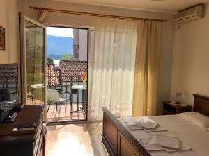 a bedroom with a bed and a view of a balcony at Apartments Luka in Budva