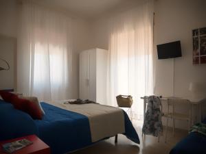 una camera con letto, scrivania e finestra di Minturnae Hotel a Scauri