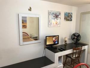 a room with a desk with a tv and a mirror at Casa Bianca Rais Gerbi in Finale