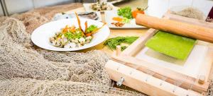 a table with a plate of food and a plate of vegetables at Aurea Hotel in Tortoreto Lido
