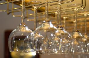 a row of wine glasses sitting on top of a rack at De Molen Guest House in Somerset West
