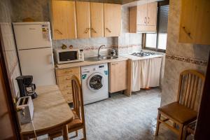 een kleine keuken met een wasmachine en een wastafel bij Apartamento Rincón del Salvador 2 in Plasencia