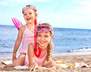 two little girls playing on the beach with toothbrushes at Aurea Hotel in Tortoreto Lido