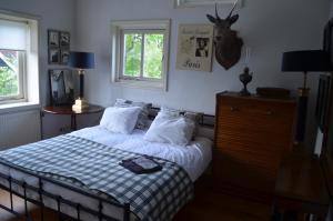 een slaapkamer met een bed met een blauwe en witte deken bij Bij Janneke in Sleeuwijk