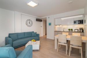 a living room with a blue couch and a table at Apartament 65 Przy plazy in Władysławowo