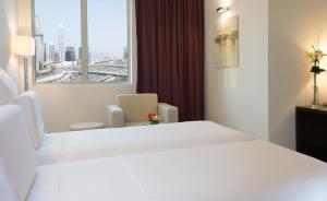 Кровать или кровати в номере Pullman Dubai Jumeirah Lakes Towers