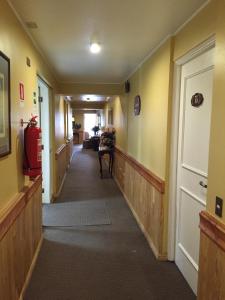 a long hallway with yellow walls and a door at Hotel Apart Colón in Puerto Montt