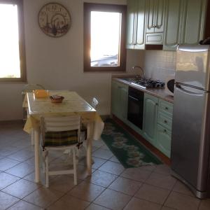 una cucina con un piccolo tavolo e un frigorifero di Casa Solaria Villetta singola panoramicissima a Costa Rei